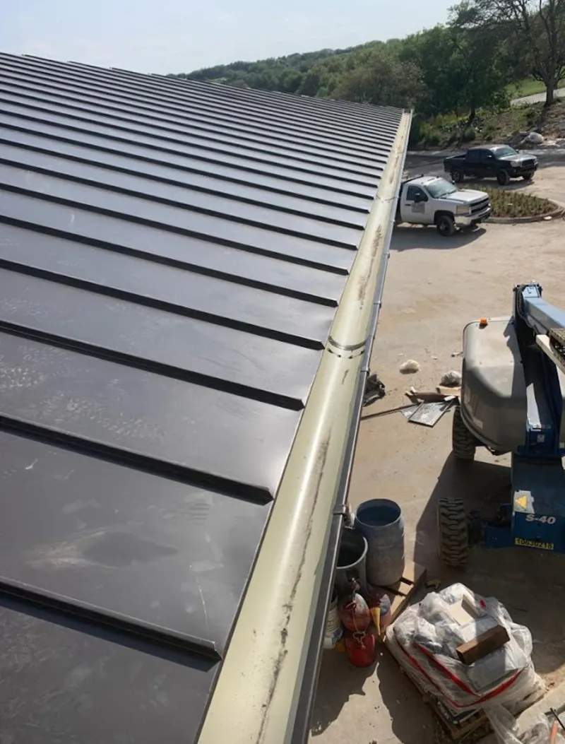 Standing seam panel and gutter detail on a metal roofing jobsite in Rialto